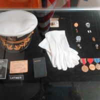 Military hat, gloves, and medals.