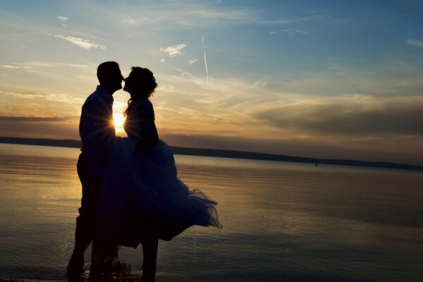 Beautiful young wedding couple standing on the beach